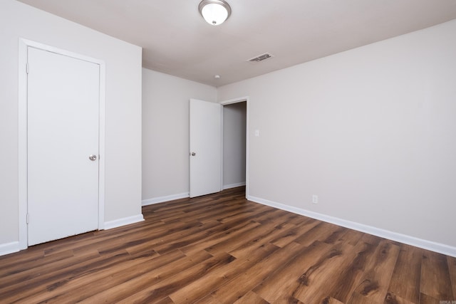 unfurnished bedroom featuring visible vents, baseboards, and wood finished floors