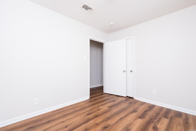 empty room with visible vents, baseboards, and wood finished floors