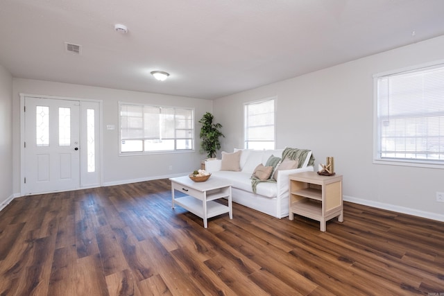 living room featuring dark wood finished floors, visible vents, and baseboards