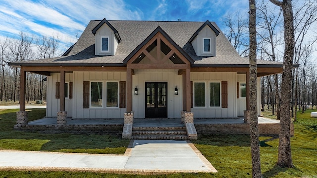 view of front of property with covered porch, board and batten siding, a shingled roof, and french doors