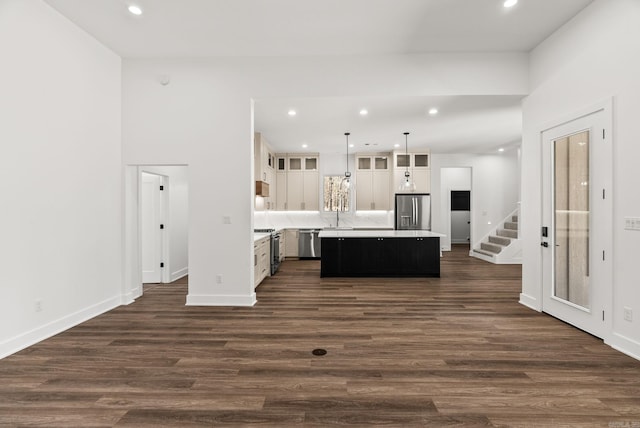 kitchen with white cabinetry, dark wood-style floors, a kitchen island, and stainless steel appliances