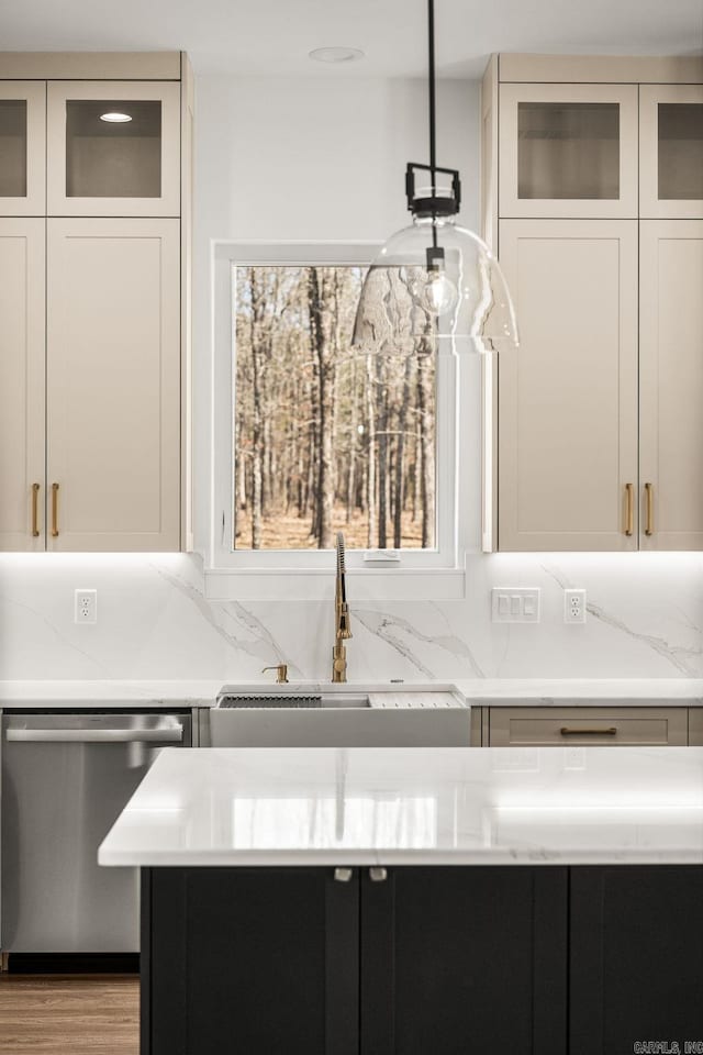 room details featuring stainless steel dishwasher, glass insert cabinets, backsplash, and a sink