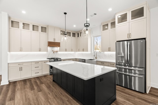 kitchen featuring visible vents, dark wood-type flooring, a sink, a kitchen island, and appliances with stainless steel finishes