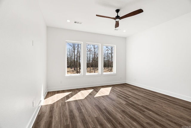 unfurnished room with dark wood finished floors, visible vents, recessed lighting, and baseboards