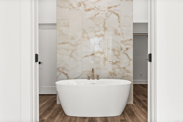 full bathroom featuring a freestanding tub and wood finished floors