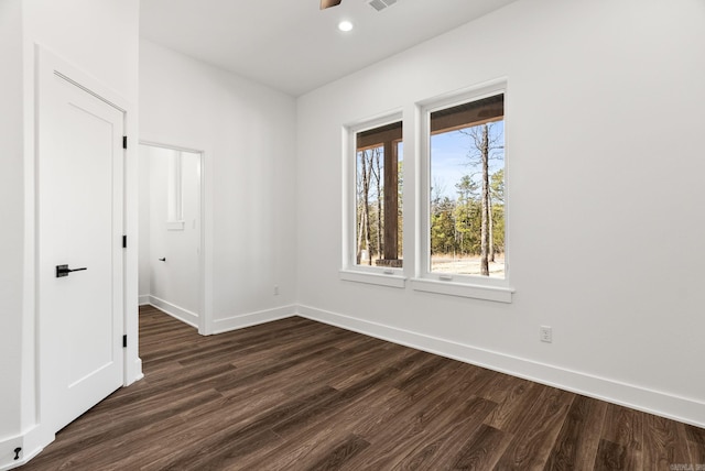 spare room featuring dark wood-type flooring, recessed lighting, baseboards, and visible vents