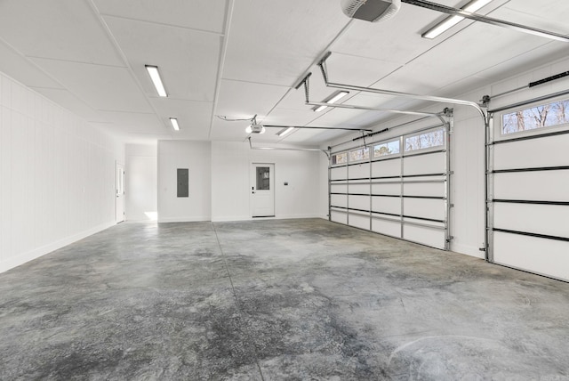 garage with electric panel, baseboards, and a garage door opener