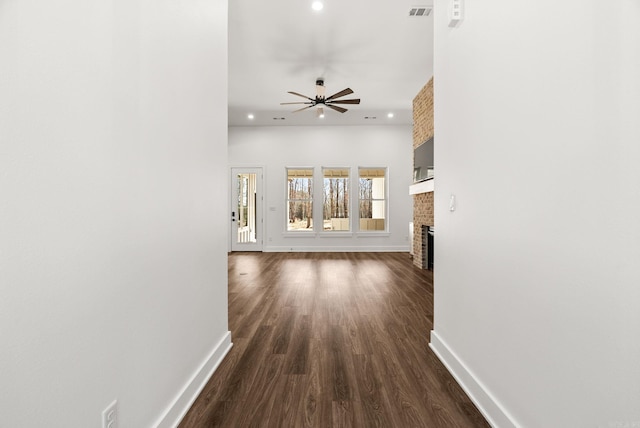 corridor with recessed lighting, visible vents, baseboards, and dark wood-type flooring