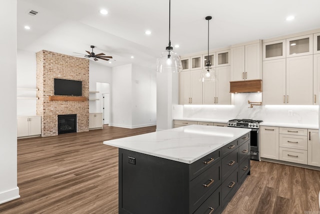 kitchen with dark cabinetry, gas range, white cabinets, and a center island