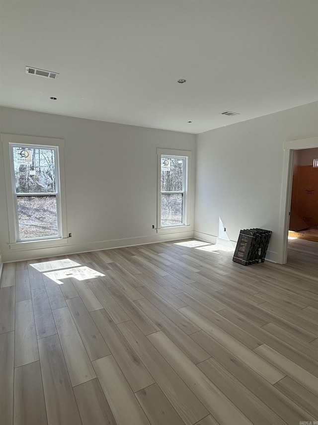 unfurnished room with visible vents and light wood-style floors