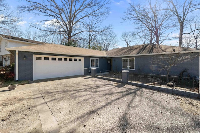 ranch-style home with brick siding, a garage, driveway, and a fenced front yard