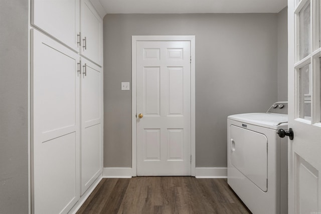 clothes washing area with baseboards, cabinet space, washer / dryer, and dark wood-style floors