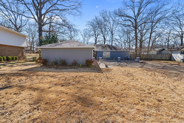 rear view of house with brick siding and fence