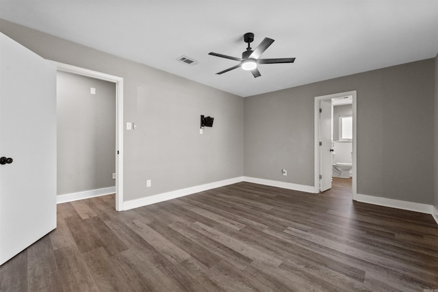 spare room featuring visible vents, baseboards, ceiling fan, and dark wood-style flooring