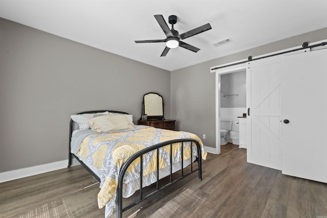 bedroom featuring a ceiling fan, wood finished floors, visible vents, baseboards, and a barn door