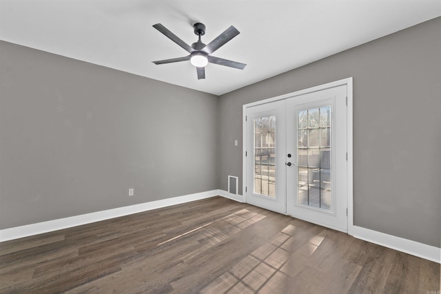 empty room with ceiling fan, french doors, baseboards, and dark wood finished floors