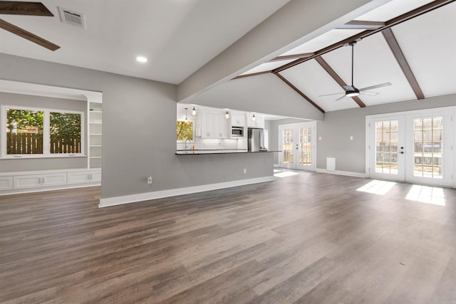 unfurnished living room with french doors, dark wood-type flooring, and beamed ceiling