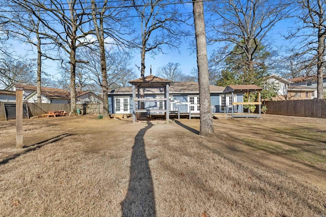 back of property featuring french doors, a fenced backyard, and a wooden deck