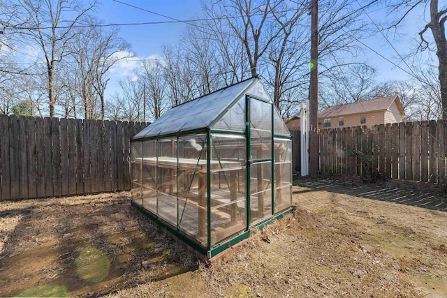 view of greenhouse with a fenced backyard