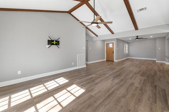 unfurnished living room featuring beamed ceiling, wood finished floors, visible vents, and baseboards