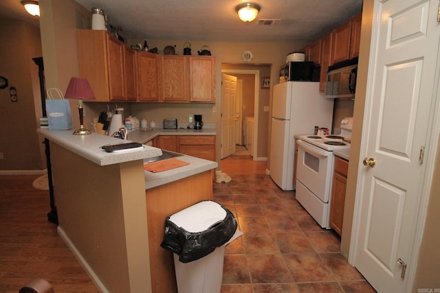 kitchen with visible vents, a kitchen bar, white electric range oven, a peninsula, and light countertops