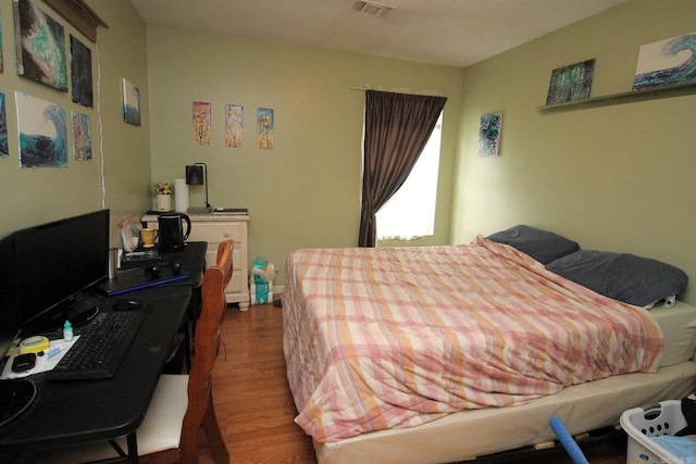 bedroom featuring visible vents and wood finished floors