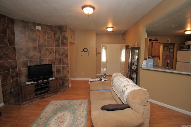 living area with baseboards and wood finished floors