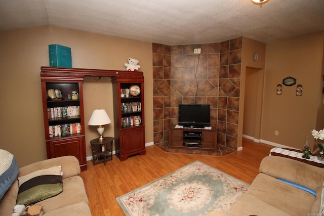 living area with baseboards and wood finished floors