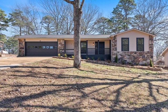 view of front of home featuring a garage, stone siding, and concrete driveway