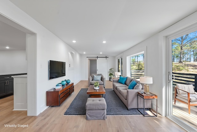 living area featuring recessed lighting, light wood-type flooring, and a barn door