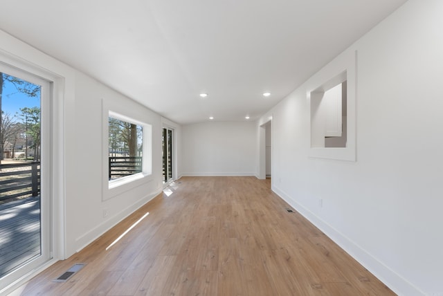 corridor featuring visible vents, recessed lighting, baseboards, and light wood-style floors