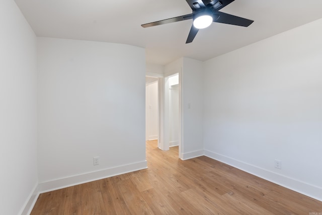 spare room featuring light wood-style flooring, baseboards, and ceiling fan