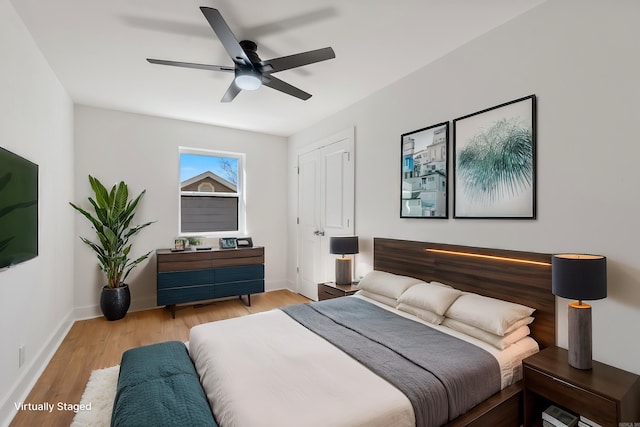 bedroom with a ceiling fan, baseboards, and wood finished floors