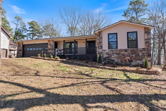 view of front of home with stone siding, a porch, and an attached garage