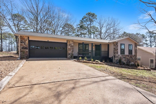 view of front facade featuring a garage, stone siding, covered porch, and driveway