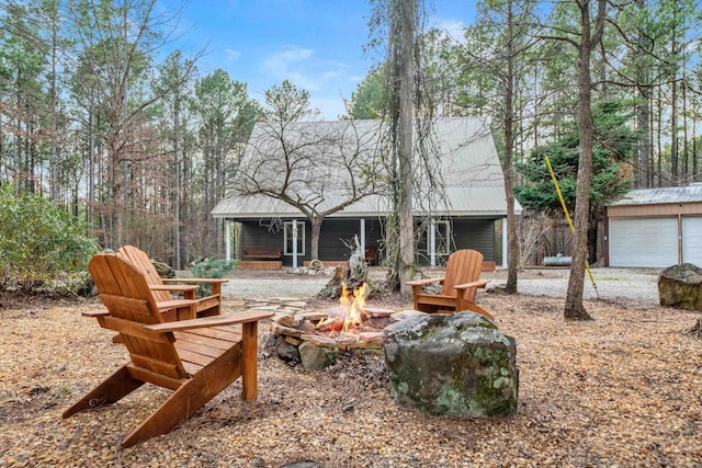 back of property with a fire pit and an outdoor structure