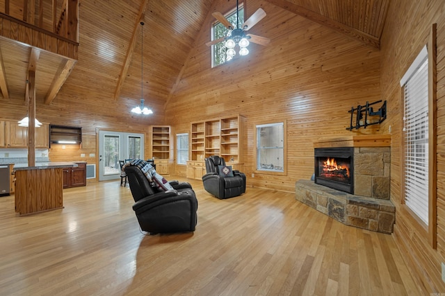 living room with wooden walls, ceiling fan, wood ceiling, light wood-type flooring, and a fireplace