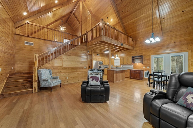 living area with light wood-type flooring, wood walls, and wooden ceiling