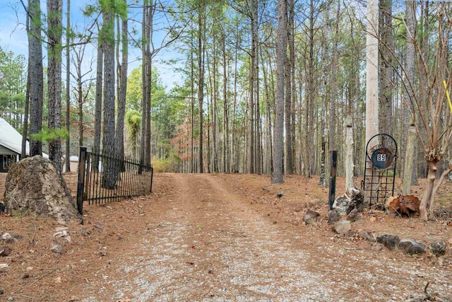 view of road with a gated entry and dirt driveway