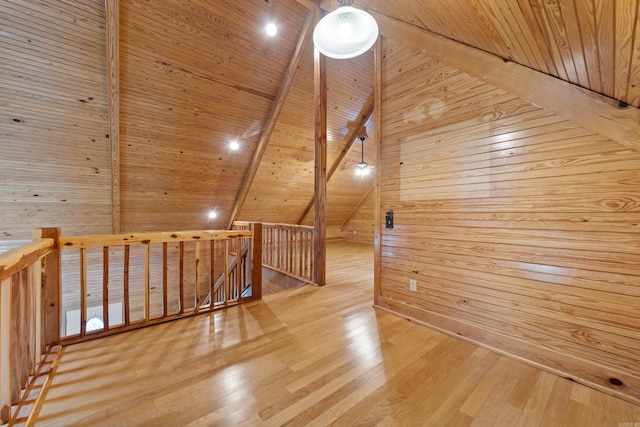 additional living space featuring wooden ceiling, lofted ceiling with beams, wood finished floors, and wood walls