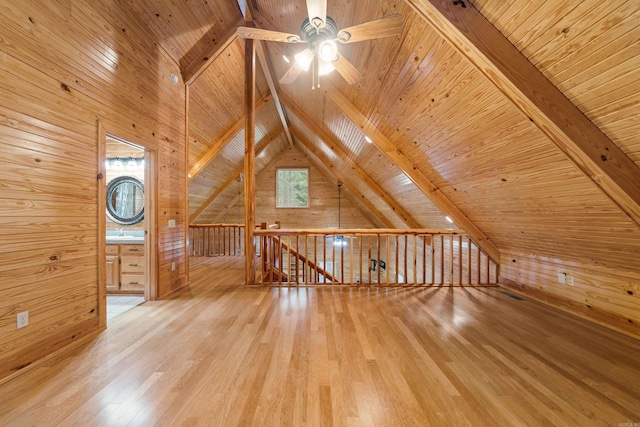 additional living space featuring wood finished floors, lofted ceiling with beams, a sink, wood walls, and wooden ceiling