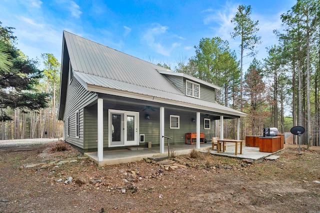 rear view of house featuring metal roof, a patio, french doors, and a hot tub