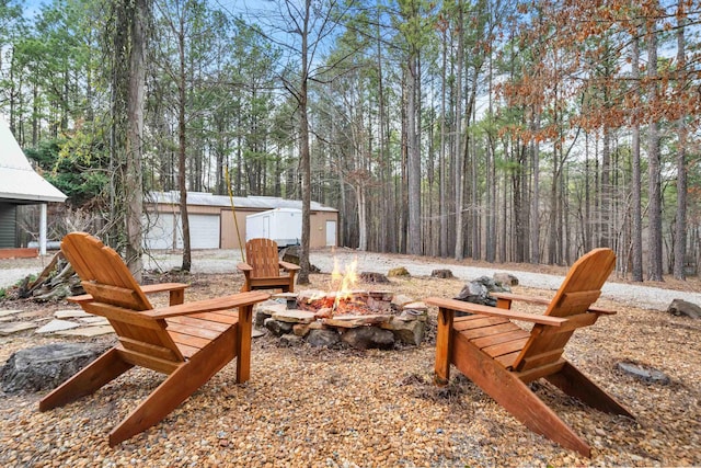 view of yard featuring an outdoor structure and an outdoor fire pit