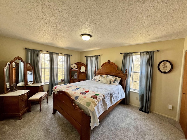 bedroom featuring a textured ceiling, multiple windows, baseboards, and light carpet