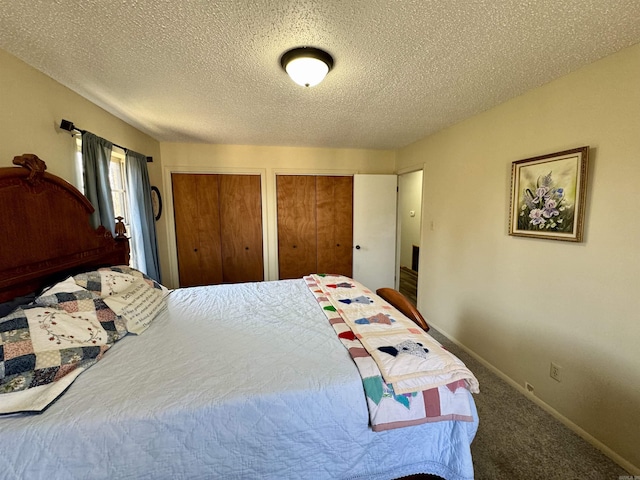 bedroom with baseboards, multiple closets, a textured ceiling, and carpet flooring