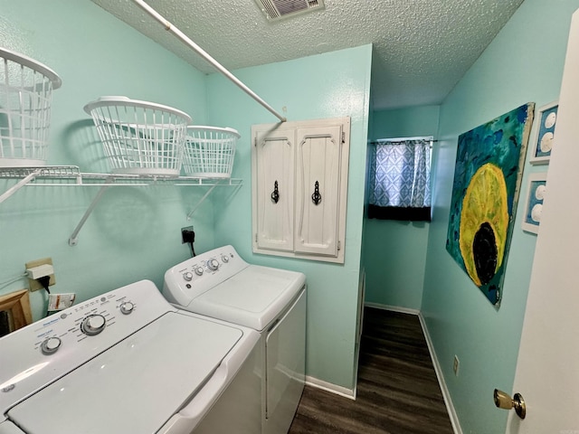 laundry area featuring dark wood-style floors, visible vents, baseboards, a textured ceiling, and washing machine and dryer