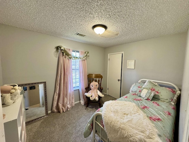 bedroom with visible vents, carpet floors, and a textured ceiling