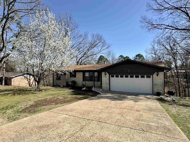 ranch-style house featuring a garage, a front lawn, brick siding, and driveway