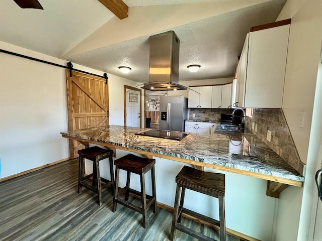 kitchen featuring a sink, a barn door, stainless steel fridge with ice dispenser, island range hood, and black electric stovetop