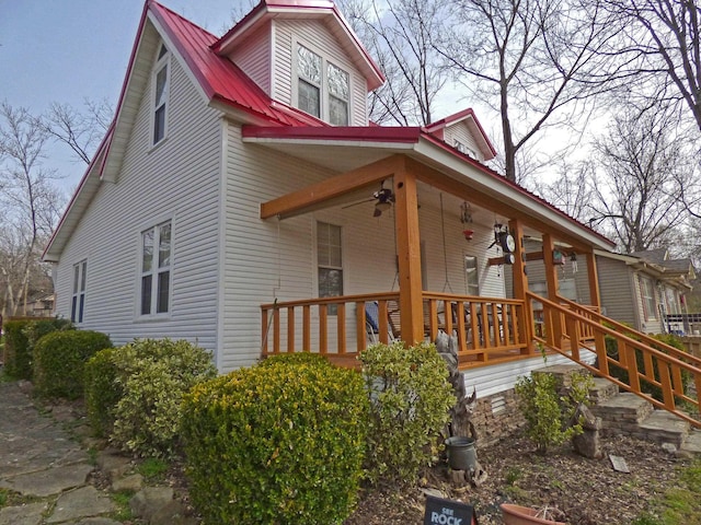 view of side of home featuring covered porch and metal roof